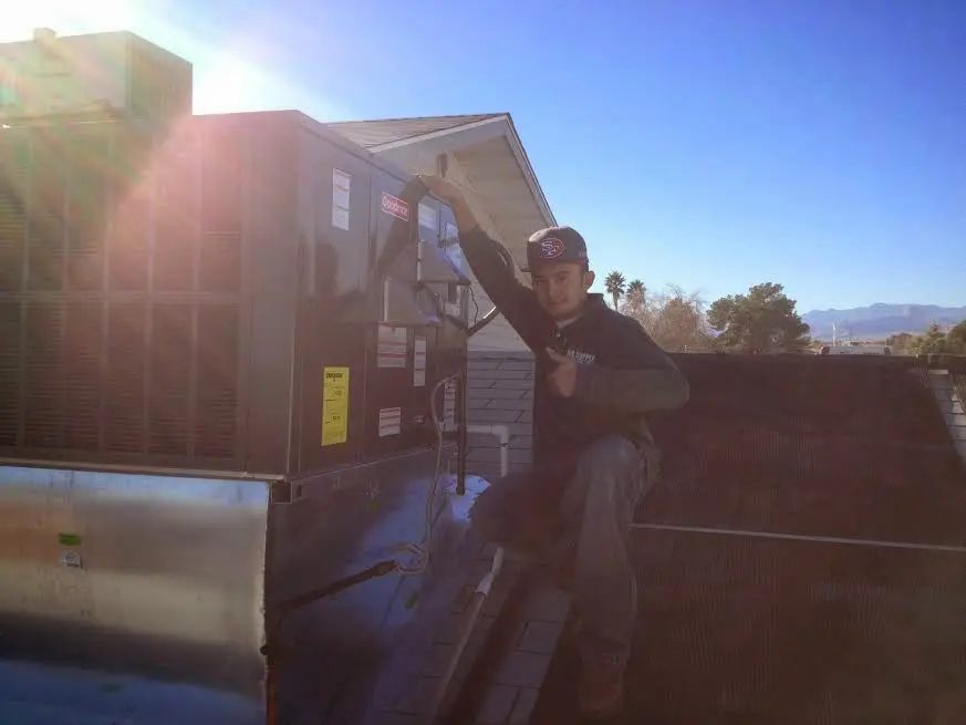 HVAC technician performing AC Tune-Up on a rooftop unit in Richmond